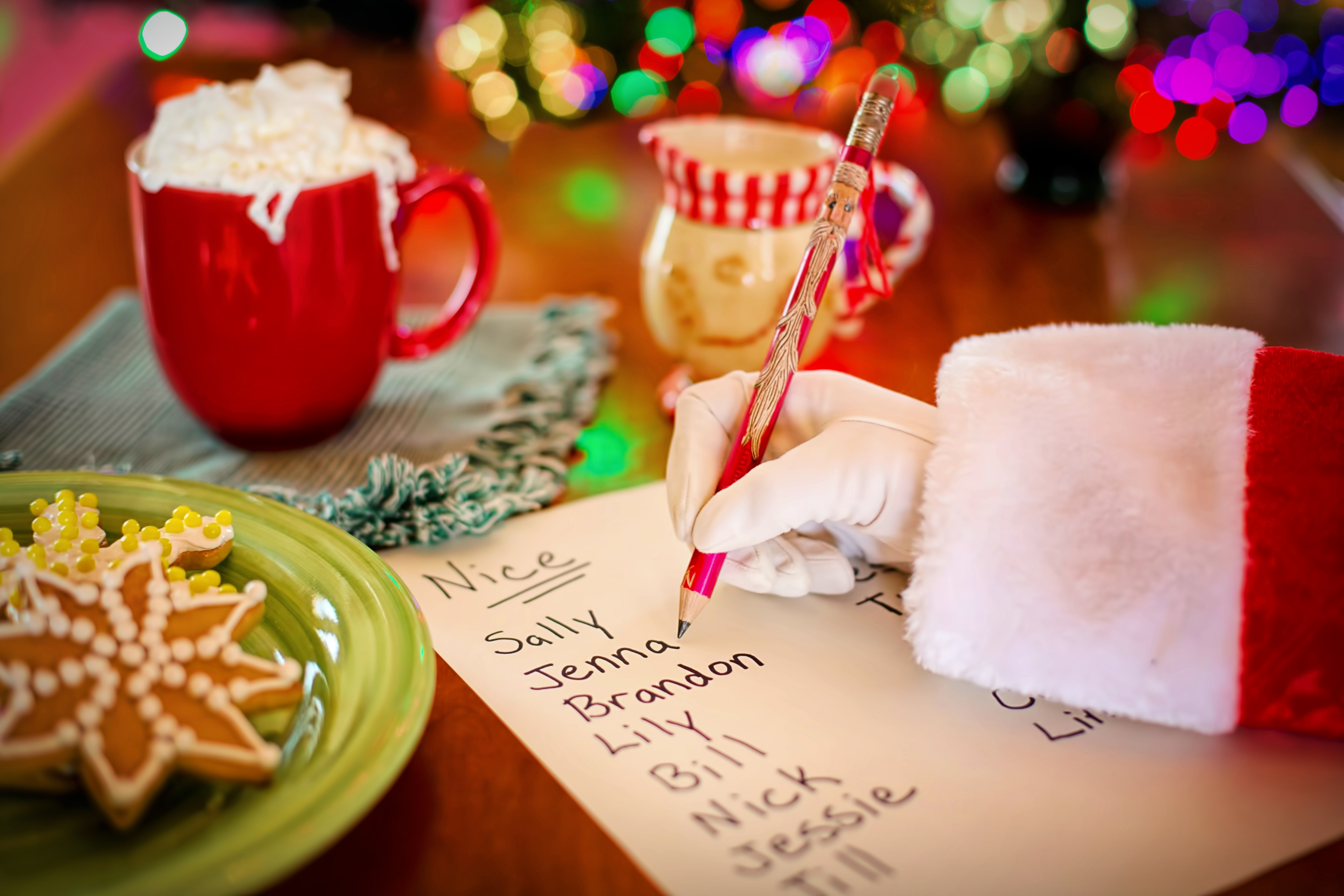 santa sleeve and hand writing a list of childrens names
